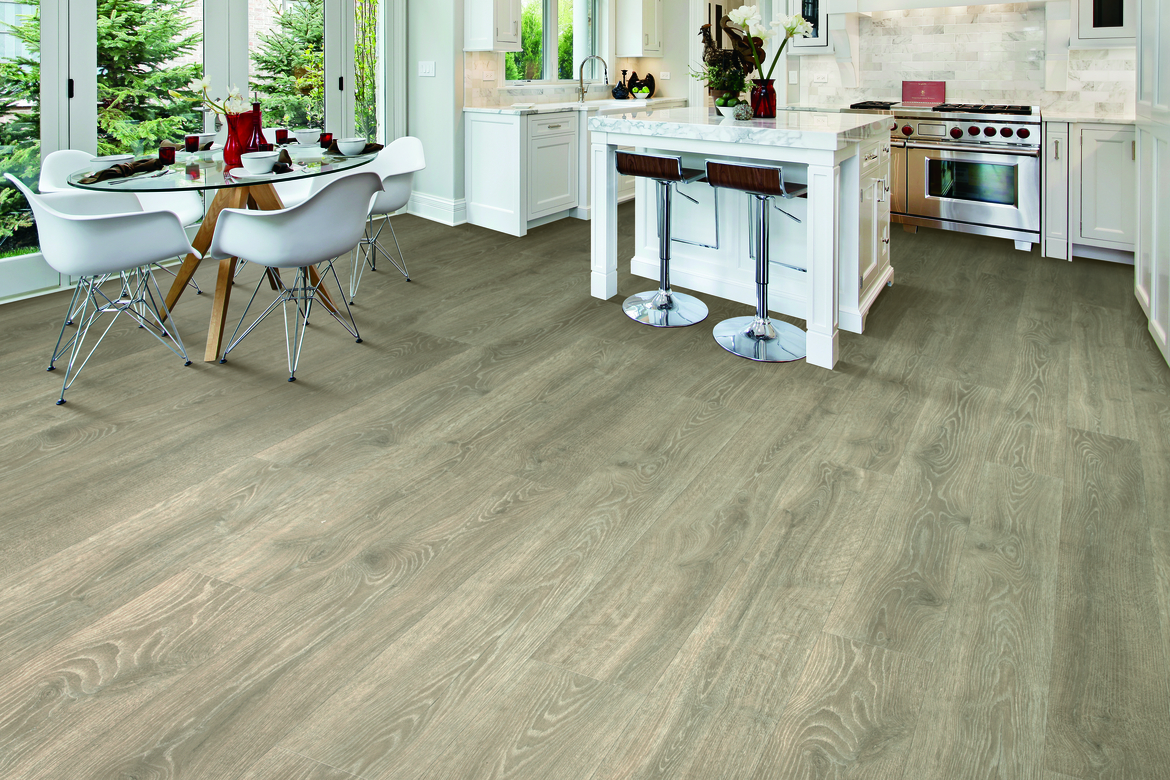 Kitchen with laminate flooring, dining table, and white cabinetry